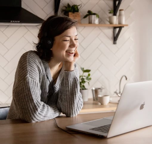 woman video chatting on her computer in her kitchen