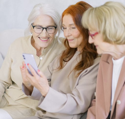 three older women video chatting with someone on a phone